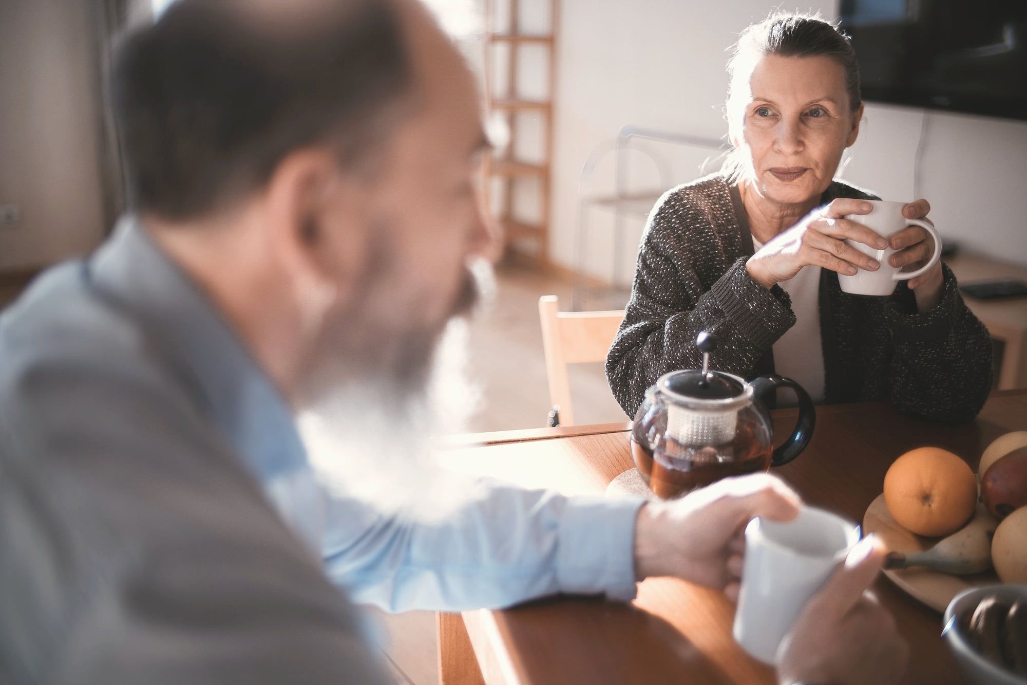 Un couple de retraités prend le café dans la cuisine.